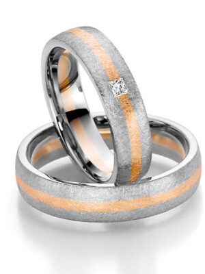 Eheringe mit goldenen Streifen und Diamant Zwei Trauringe aus Silber mit einer orangefarbenen Linie und einem kleinen Diamanten in der Mitte.