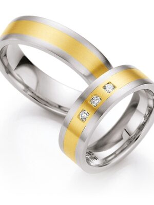 trauringe-moderne-zeitlose-gestaltung Zwei moderne Trauringe mit klaren Linien liegen nebeneinander und verkörpern zeitlose Schlichtheit und elegante Harmonie